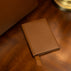Leather passport holder on a vintage table near an old lamp and a luxury tote bag
