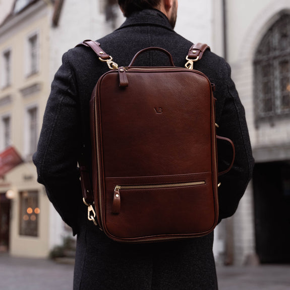 Von Baer 10x high-quality leather travel backpack in brown, perfect for carrying a camera, worn by a handsome man.