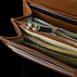 Von Baer Allure large cognac tan full-grain leather accordion wallet with RFID protection, shown in a close-up highlighting its gold-tone metal puller against a black background.