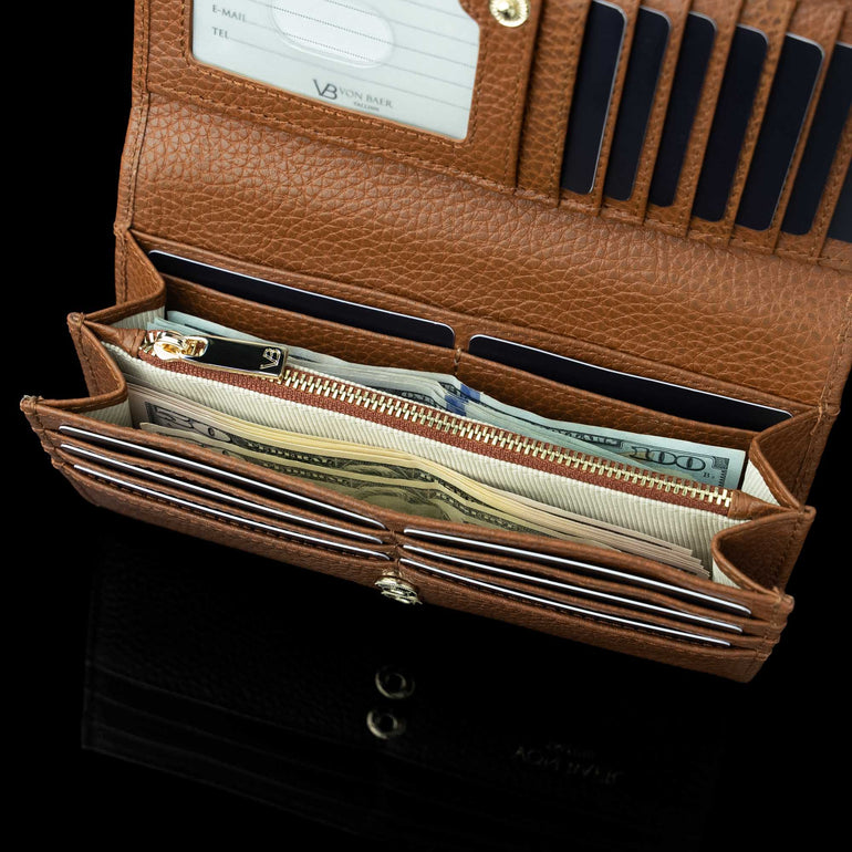 Von Baer Allure large cognac tan full-grain leather accordion wallet with RFID protection, shown open with dollar notes in its double compartment against a black background.
