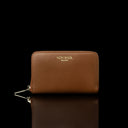 Von Baer Celeste small tan full-grain leather zip-around wallet with a gold-tone zipper, displayed in a front view against a black background.