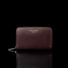 Von Baer Celeste small burgundy full-grain leather zip-around wallet with a gold-tone zipper, displayed in a front view against a black background.