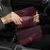 Von Baer Celeste small burgundy full-grain leather zip-around wallet demonstrated inside the Isabella small leather crossbody bag interior, held open inside a car setting with gold-tone hardware and gold-embossed Von Baer Tallinn branding.