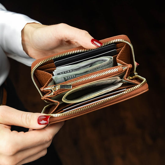 Von Baer Celeste small leather zip around wallet small compact leather purse wallet held in a woman’s hands showing cash compartments and card slots