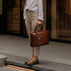 Von Baer City business luxury leather laptop bag for women in solid brown, carried by a female model.