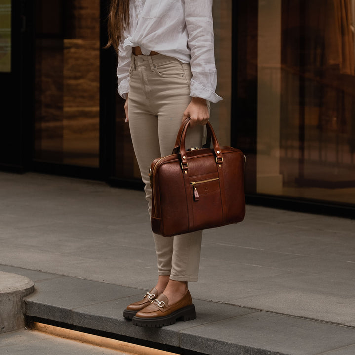 Von Baer City business luxury leather laptop bag for women in solid brown, carried by a female model.