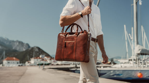 von baer city large leather laptop bag luxury design brown with shoulder strap in hands of stylish male model in harbour slider