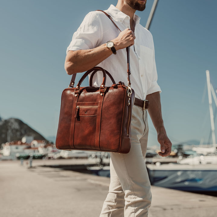 von baer city large leather laptop bag luxury design brown with shoulder strap in hands of stylish male model in harbour