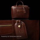 A Von Baer City leather laptop bag showing an example of personalization with embossed initials on the attached luggage tag.