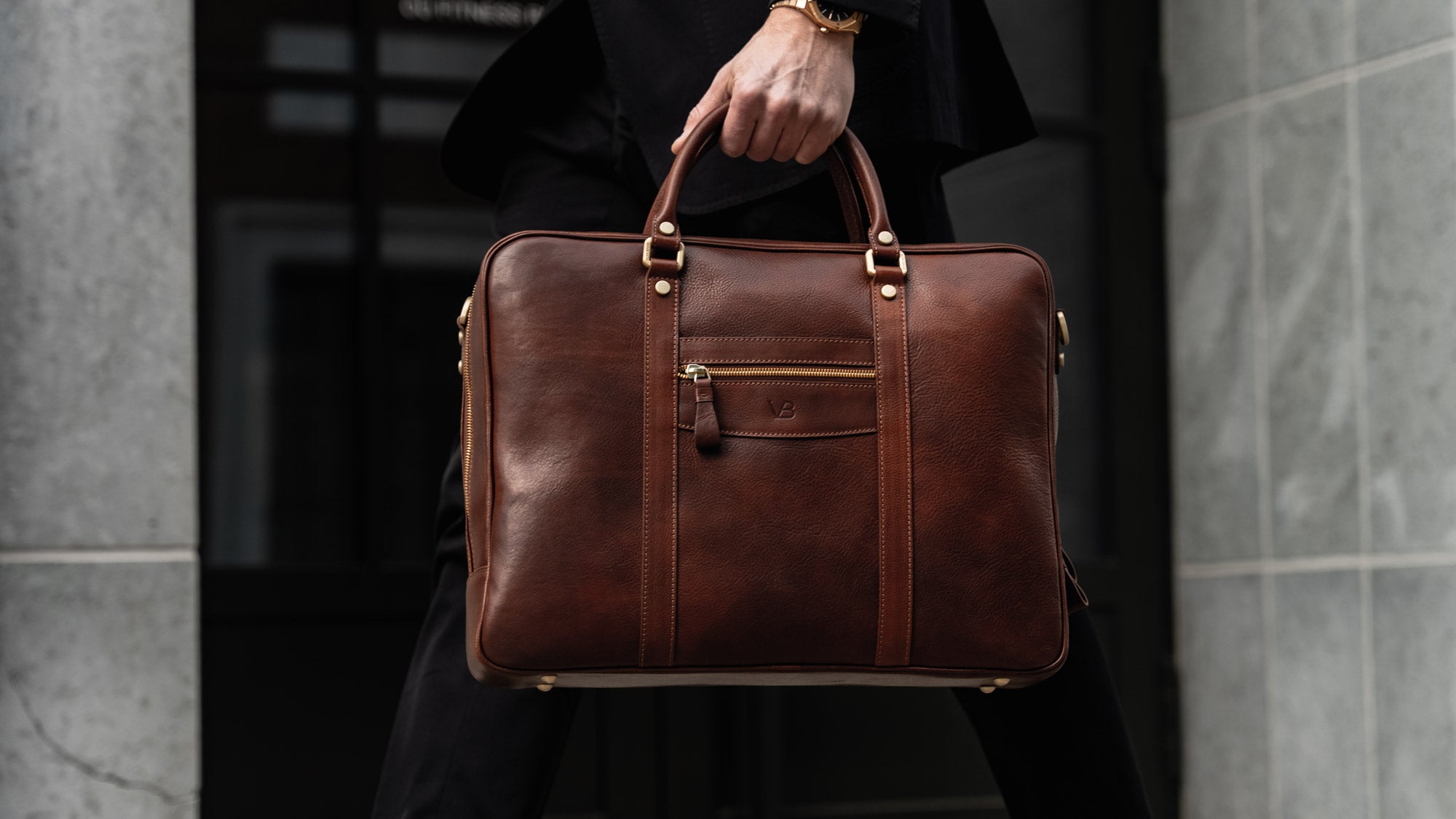 Von Baer City top luxurious large leather men's laptop bag for lawyers, carried by a man in a suit, slider.