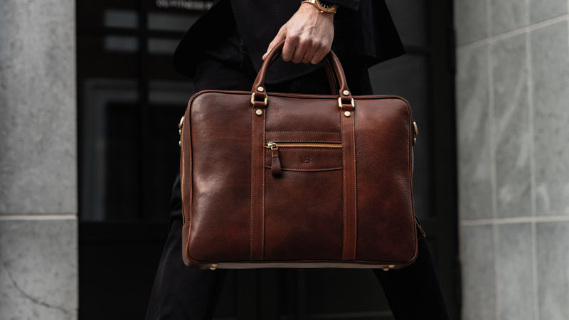 Von Baer City top luxurious large leather men's laptop bag for lawyers, carried by a man in a suit, slider.