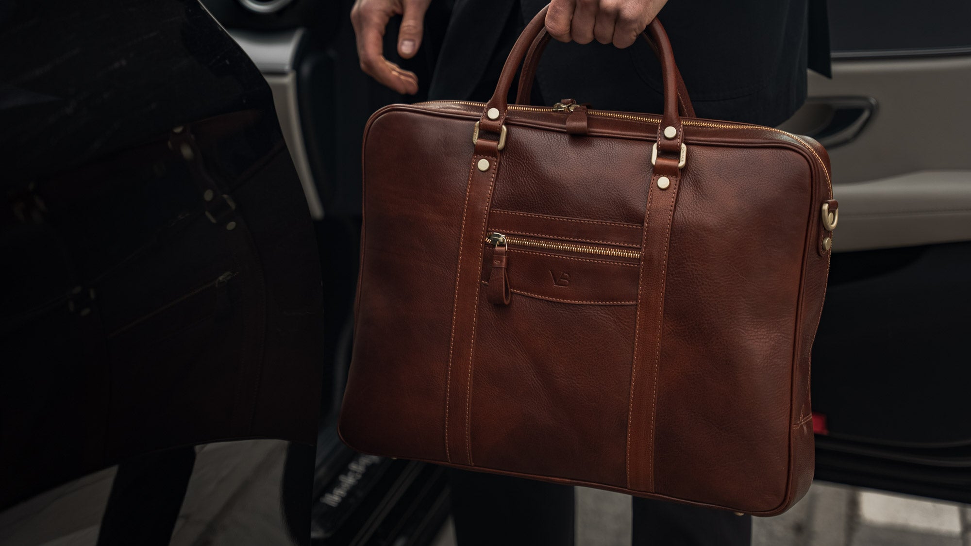 von baer city top luxurious large leather mens laptop bag for work brown carried by man in a suit near mercedes slider