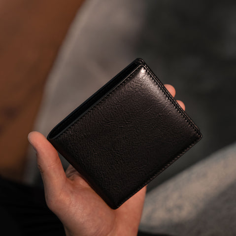 Von Baer Classic bifold Italian leather luxury men's wallet in black color held by a male model