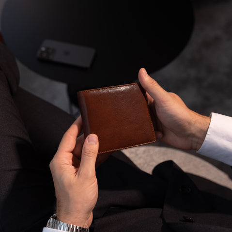 Von Baer Classic bifold Italian leather luxury men's wallet held by a male model in luxury apartments