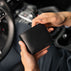 Von Baer Classic compact minimalist bifold leather wallet in black, held in a man's hands