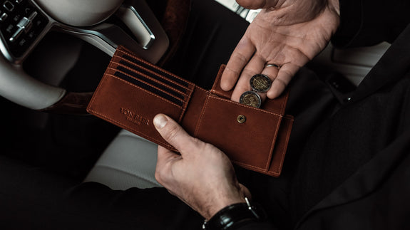 A lifestyle image of the Von Baer classic bifold luxurious leather wallet for men in brown, open to reveal coins, emphasizing its functionality and premium quality.