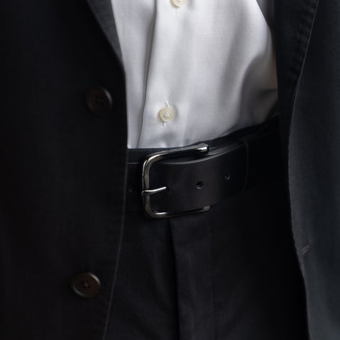 Von Baer classic luxury full-grain leather belt for men in black, with a buckle, worn with a black suit.