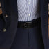 Von Baer classic luxury full-grain leather belt for men in black, with a buckle, worn with a navy blue suit.
