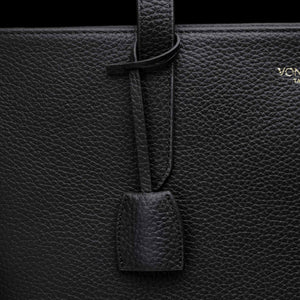 Von Baer decorative leather clip with snap hook in black color on tote bag, front view showing premium hardware detail.