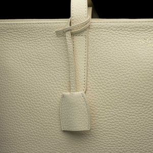 Von Baer decorative leather clip with snap hook in cream white color on tote bag, front view showing premium hardware detail.