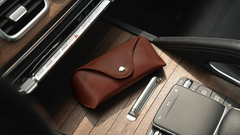 A brown Von Baer Deluxe luxury leather sunglasses and glasses case on a wooden panel in a car, an ideal gift for women.