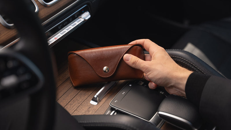 A brown Von Baer Deluxe luxury leather sunglasses and glasses case in a car.
