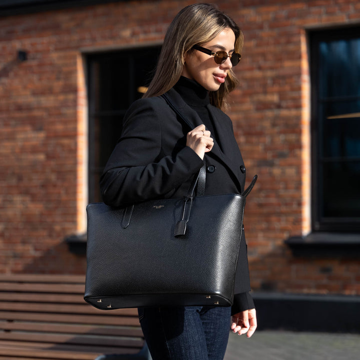 Von Baer Elegance luxury large leather tote bag in black, held by a female model standing against an urban modern building