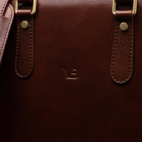 Men’s Von Baer Elegant high-quality slim full-grain leather laptop bag in brown, showcasing the VB logo close-up and leather texture.