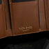 Von Baer Elise women's cognac pebbled leather trifold wallet shown in close-up against a black background, highlighting its interior texture and gold-embossed Von Baer Tallinn branding.