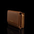 Von Baer Elise women's cognac pebbled leather trifold wallet shown from a side view on a reflective black background, highlighting its gold zipper hardware and gold-embossed Von Baer Tallinn logo.