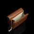 Von Baer Elise women's cognac pebbled leather trifold wallet shown open against a solid black background, featuring a cream-colored interior lining and gold-tone zip coin pocket hardware.