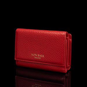 Von Baer Elise women's red pebbled leather trifold wallet shown from a three-quarter front view on a reflective black surface, featuring gold-embossed Von Baer Tallinn branding.