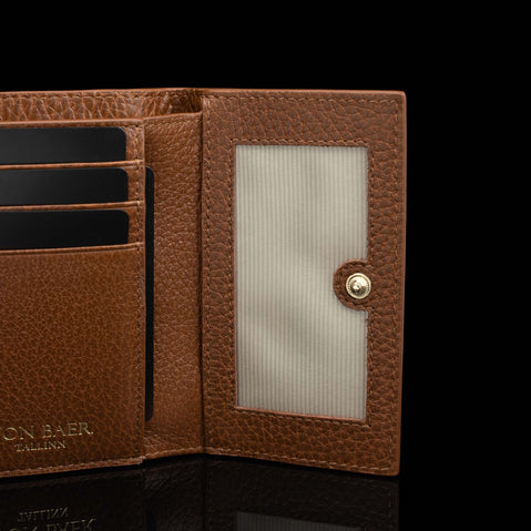 Von Baer Elise women's cognac pebbled leather trifold wallet displayed open on a black background, showing card slots, an ID window with snap closure, and embossed Von Baer Tallinn branding.