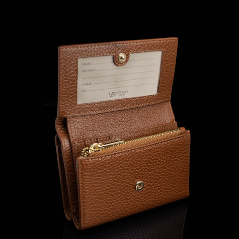Von Baer Elise women's cognac pebbled leather trifold wallet displayed open against a black background, featuring card slots, a zippered compartment, and an interior ID window with snap closure.