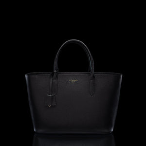 Von Baer Estelle black leather tote bag for women, shown from the front with structured top handles, pebbled leather texture, leather clochette and gold-tone logo.