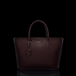 Von Baer Estelle burgundy small leather tote bag for women, shown from the front with structured top handles, pebbled leather texture, hanging clochette and gold-tone logo.