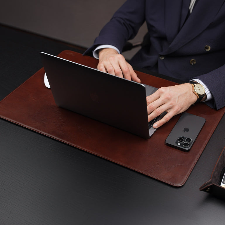 Von Baer Executive brown leather desk pad and laptop mat used by businessman in suit working on MacBook