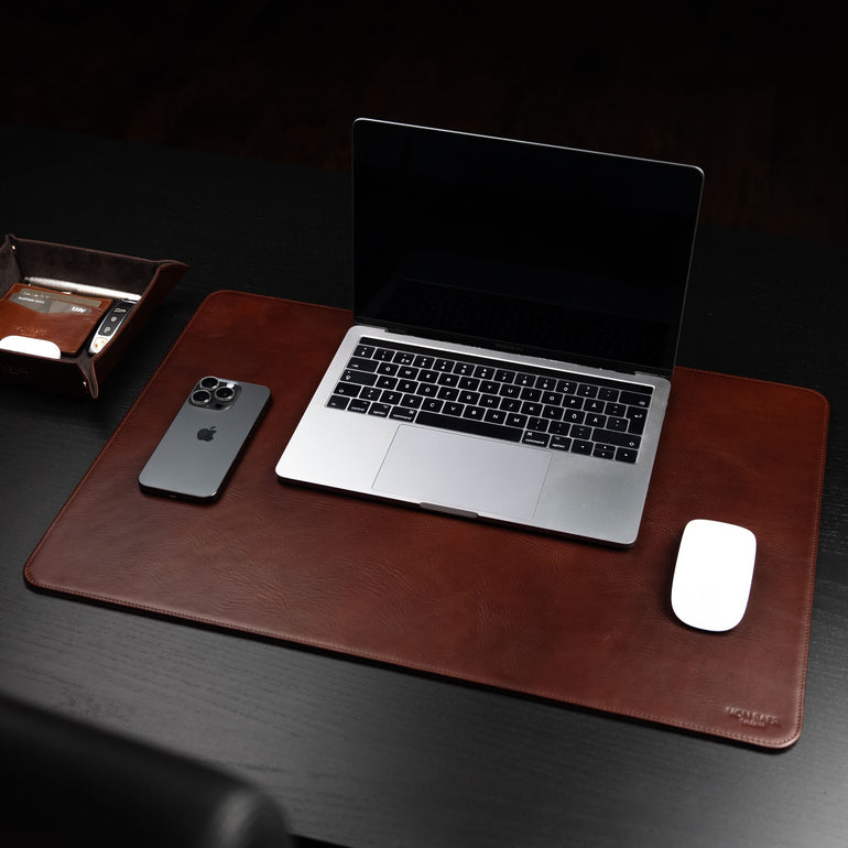 Von Baer Executive luxury leather desk pad in brown on a dark wood table with an open MacBook, iphone and mouse.