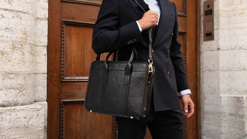 An exquisite, slim, black Von Baer full-grain leather laptop briefcase with a shoulder strap for work
