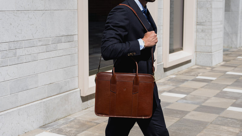 An exquisite, slim, brown Von Baer full-grain leather laptop briefcase with a shoulder strap