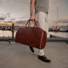 Von Baer Grand Large Full-Grain Leather Garment Travel Bag (Man Carrying, Sunset Yacht Marina)