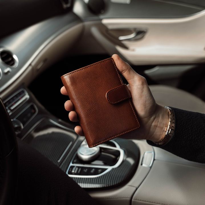 Von Baer Heritage premium men's leather trifold wallet in solid brown, in the car.