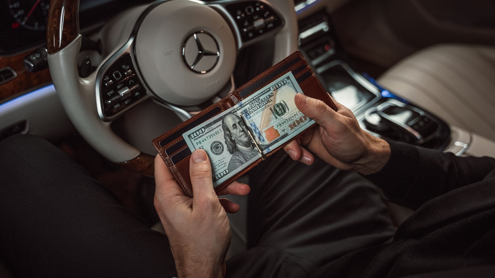 A lifestyle shot of the Von Baer leather money clip, a compact men's wallet in solid brown, highlighting its sleek and premium design.