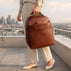 Von Baer Liberty luxury women’s brown full-grain Italian leather backpack with model on a New York rooftop, stylish bag for work and travel.