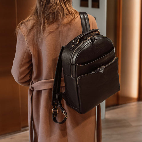 Von Baer Liberty stylish women's full-grain leather backpack in black, worn by a woman in a beige coat