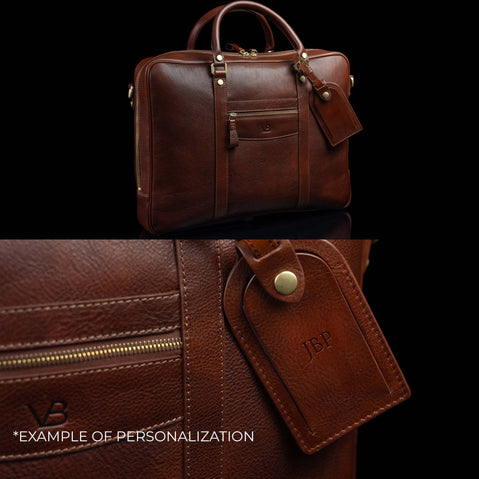 Luxurious Von Baer City large laptop bag made of full-grain leather, with a large luggage tag showing an example of personalization with embossed initials