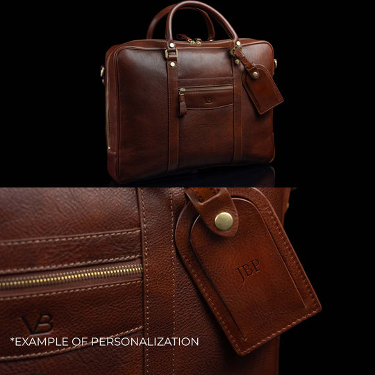 Luxurious Von Baer City large laptop bag made of full-grain leather, with a large luggage tag showing an example of personalization with embossed initials