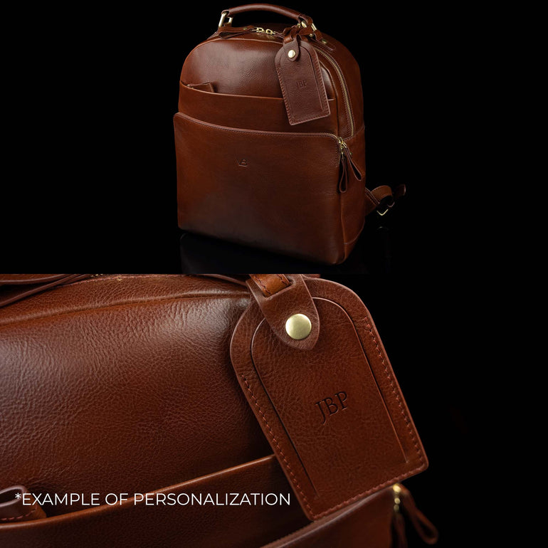 Luxurious Von Baer full-grain leather laptop backpack with a large luggage tag, showcasing an example of personalization with embossed initials