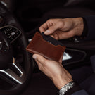 von baer luxury element leather card case wallet solid brown in the hands of businessman