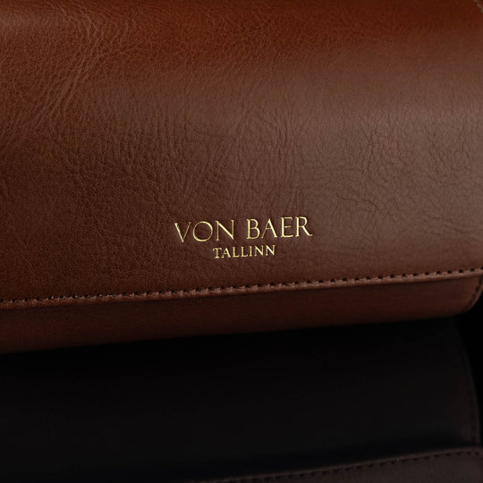 A close-up of the 'Von Baer Tallinn' logo on a brown luxury leather watch roll.